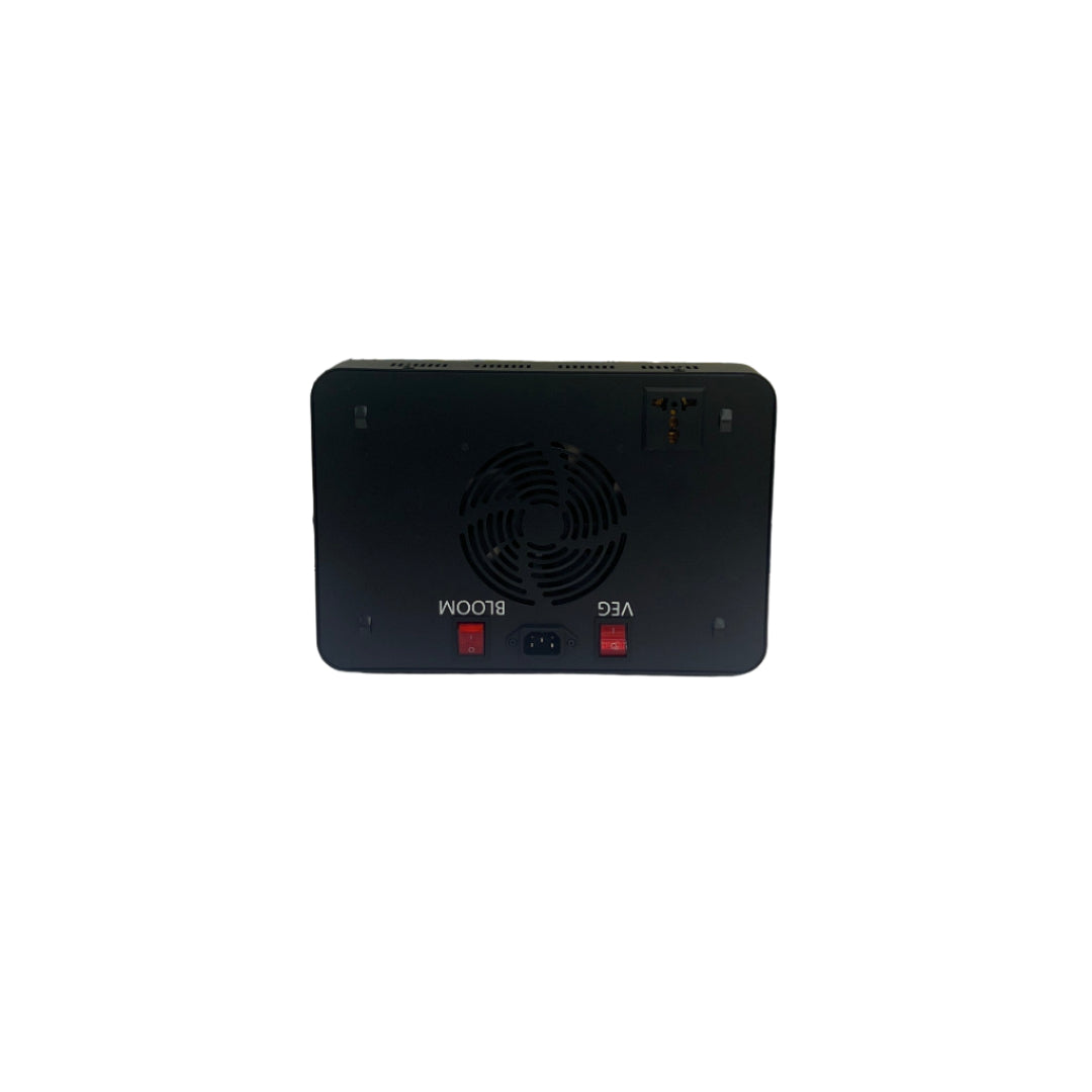 Black electronic device on a tiled wall with tools and equipment below