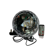Round electronic device with wires and a remote control on a white surface