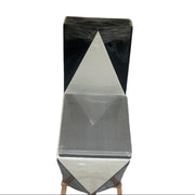 Geometric sculpture with black and white triangular design on a stand against a white background