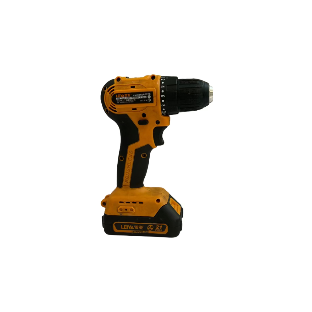 Yellow and black cordless drill on a white surface with a wall and tools in the background